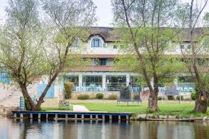 a building with a dock next to a body of water at Pensiunea Pelicanul in Dunavăţu de Jos