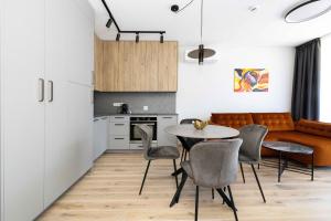 a kitchen and dining room with a table and chairs at Vanagupes Park Apartment, By Cohost in Palanga