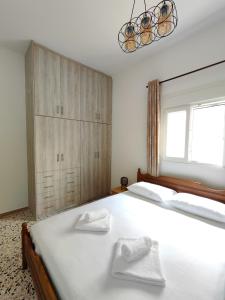 a bedroom with a large white bed with two towels on it at Oasis Apartments in Perissa +46 photos