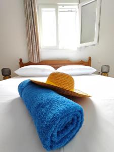 a bed with a blue blanket and a hat on it at Oasis Apartments in Perissa