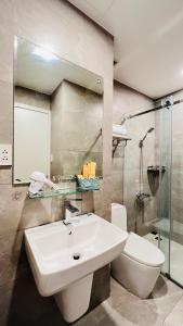 uma casa de banho com um lavatório branco e um WC. em Amanda Boutique -Serviced Apartment - Hotel Bình Dương em Thu Dau Mot