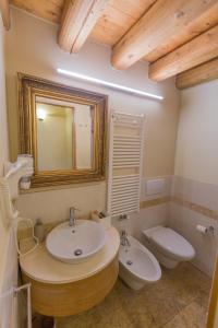 a bathroom with a sink and a toilet and a mirror at Casa sul Fiume County House in Solagna