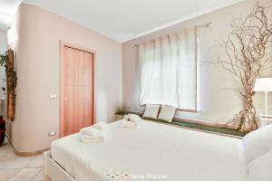 een witte slaapkamer met een bed en een raam bij Affittacamere Niria, Terre Marine in Volastra