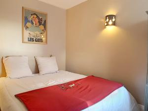 レ・ジェにあるAppartement Les Gets, 2 pièces, 4 personnes - FR-1-454-56の赤い毛布が敷かれたベッドが備わる客室です。