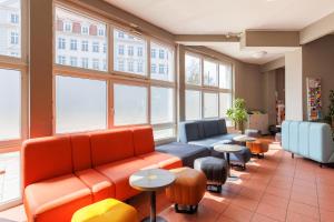 una sala d'attesa con divani, tavoli e finestre di a&o München Hackerbrücke a Monaco
