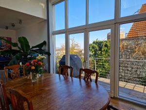 a dining room with a wooden table and large windows at Mountains and Lakes - Villa Gaumberg in Linz