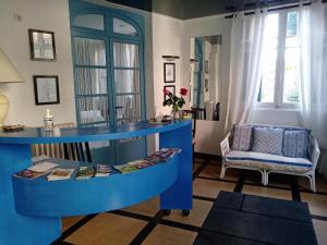 a living room with a blue table and a chair at Les Chenes Chambres D'hote in Châtel-Guyon