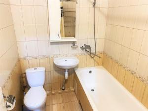 La salle de bains est pourvue de toilettes, d'un lavabo et d'une baignoire. dans l'établissement Апартаменти поруч з метро Лівобережна, à Kiev