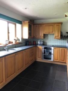 a kitchen with wooden cabinets and a stove at Nant-Y-Glyn in Llandrindod Wells