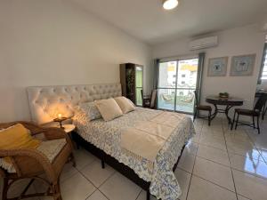 a bedroom with a bed and a table and chairs at Flat CasaSouza in Santa Maria