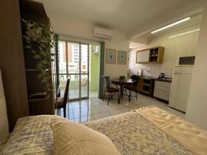 Cet appartement comprend une chambre avec un lit et une cuisine avec une table. dans l'établissement Flat CasaSouza, à Santa Maria