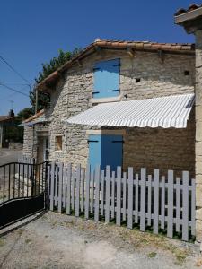 een wit hek voor een stenen huis bij Gite Bin Benaise sans linge in Pamproux