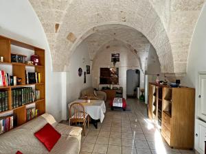a living room with a table in a room with an archway at LA CASETTA in puglia in Montalbano