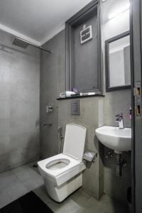 Łazienka z białą toaletą i umywalką w obiekcie SaltStayz Golf Course Road w mieście Gurgaon
