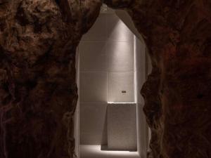 a view of a shower through a stone wall at Hiranoya in Gamagori