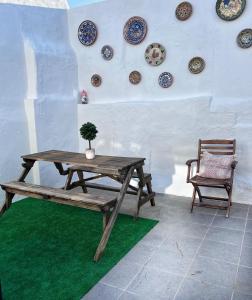 a wooden table and a chair and plates on a wall at Casa Solua in Reguengos de Monsaraz