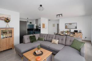 sala de estar con sofá y mesa en Seyssuel • Villa Paisible • HostisY en Seyssuel