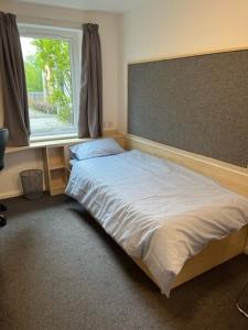 a bedroom with a large bed with a window at Cosy Studios at New Hall located in the heart of Nottingham in Nottingham