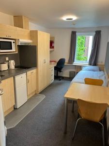a room with two beds and a table and a kitchen at Cosy Studios at New Hall located in the heart of Nottingham in Nottingham