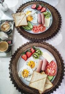 two plates of food with eggs and bread and tomatoes at Friendly Guest House in Kutaisi