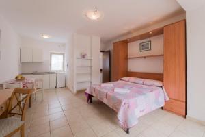 a bedroom with a bed and a table and a kitchen at Villino nel Bosco in Capoliveri