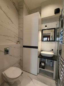 a white bathroom with a toilet and a sink at City Center Belgrade Dorćol Square in Belgrade