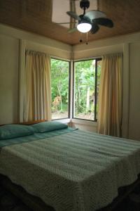 1 dormitorio con 1 cama y 2 ventanas en Casa a 26 kilómetros de Jaco rodeado de naturaleza, en Jacó
