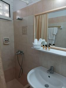 a bathroom with a sink and a shower with a mirror at Studios Antoniou in Skala