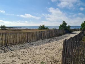a fence on the beach with the ocean in the background at Le Churchill Hôtel & Spa in Carnac