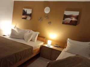 a bedroom with two beds and two pictures on the wall at Complex Turistic Cetatea Drencova 