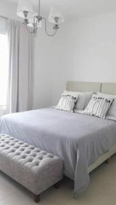 um quarto branco com uma cama grande e uma janela em Tres Arroyos Plaza San Martín em Tres Arroyos