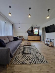 a living room with a couch and a table at Tatra Apartments z zewnętrznym jacuzzi in Biały Dunajec