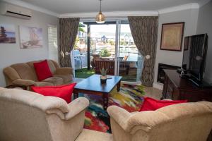 a living room with two chairs and a television at WATERFRONT 2 Bed Home with mooring at Knysna Quays in Knysna