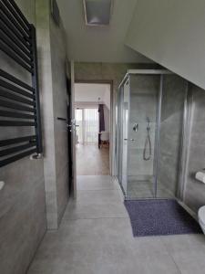 een badkamer met een inloopdouche en een glazen deur bij Tatra Apartments z zewnętrznym jacuzzi in Biały Dunajec