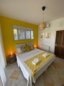 a bedroom with a large bed with yellow walls at Villa by the Lake in Karoubatika near Agios Ioannis in Agios Ioannis