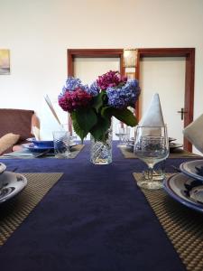 a table with a vase of purple flowers on it at Kuća za odmor TRI SUNCA in Pula