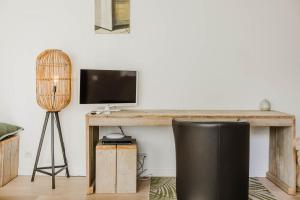 a living room with a desk with a television and a chair at B&B Villa Tartine in Puurs