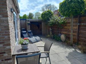 a patio with a table and chairs and a fence at Nieuw Holiday home Oostkapelle centrum in Oostkapelle
