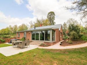 een huis met een serre met een tafel en stoelen bij Court Lodge in Taunton