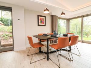 een eetkamer met een zwarte tafel en oranje stoelen bij Court Lodge in Taunton