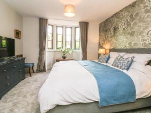 a bedroom with a large bed and a tv at Court Lodge in Taunton