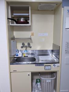 eine kleine Küche mit einer Spüle und einer Theke in der Unterkunft ⅡGood place for shopping sightseeing 買い物と観光に最適 in Fukuoka