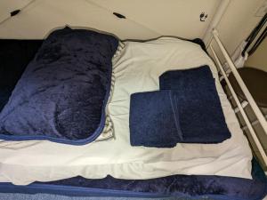 ein kleines Bett mit blauen Decken darauf in der Unterkunft ⅡGood place for shopping sightseeing 買い物と観光に最適 in Fukuoka