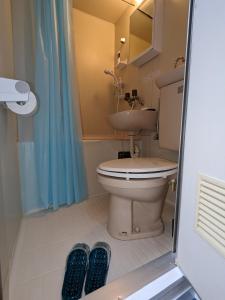 ein Bad mit einem WC, einem Waschbecken und 2 Hausschuhen in der Unterkunft ⅡGood place for shopping sightseeing 買い物と観光に最適 in Fukuoka
