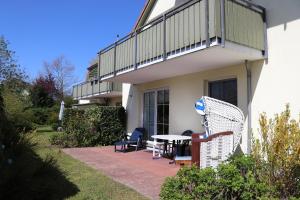 a patio with a table and chairs and a balcony at Altes Wasserwerk App 10 in Wustrow