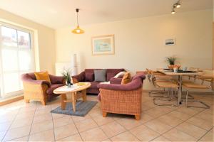 Una sala de estar con un sofá y sillas y una mesa. en Altes Wasserwerk App 13, en Wustrow