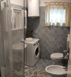 a bathroom with a washing machine and a toilet at Kuća za odmor TRI SUNCA in Pula