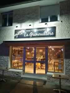un restaurante con un cartel en la parte delantera de un edificio en Hotel Restaurant La Grenouillère, en Vitré