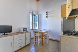 a kitchen with a table and a television and a counter at Il Quadrifoglio 3 in Procchio +8 photos