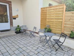 a patio with two tables and chairs and a fence at Gîte Au Coin du Chêne in Lembach